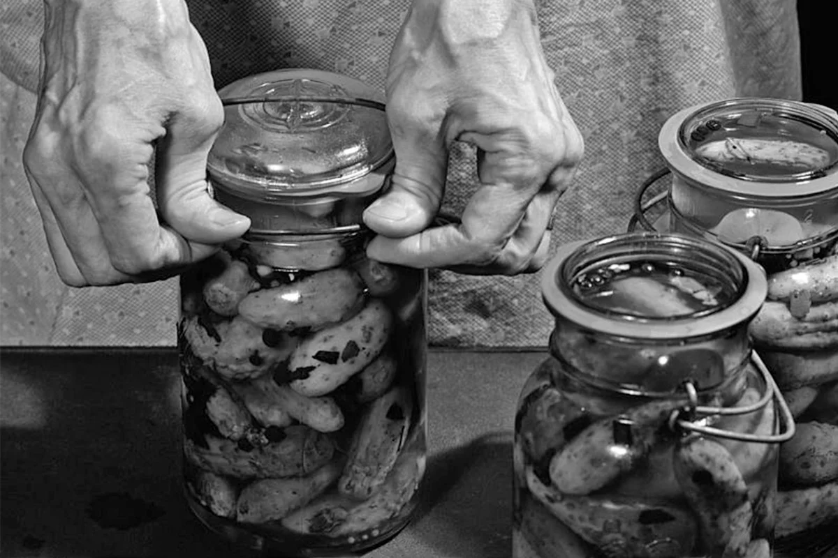 woman sealing lids on antique canning jars circa 1950