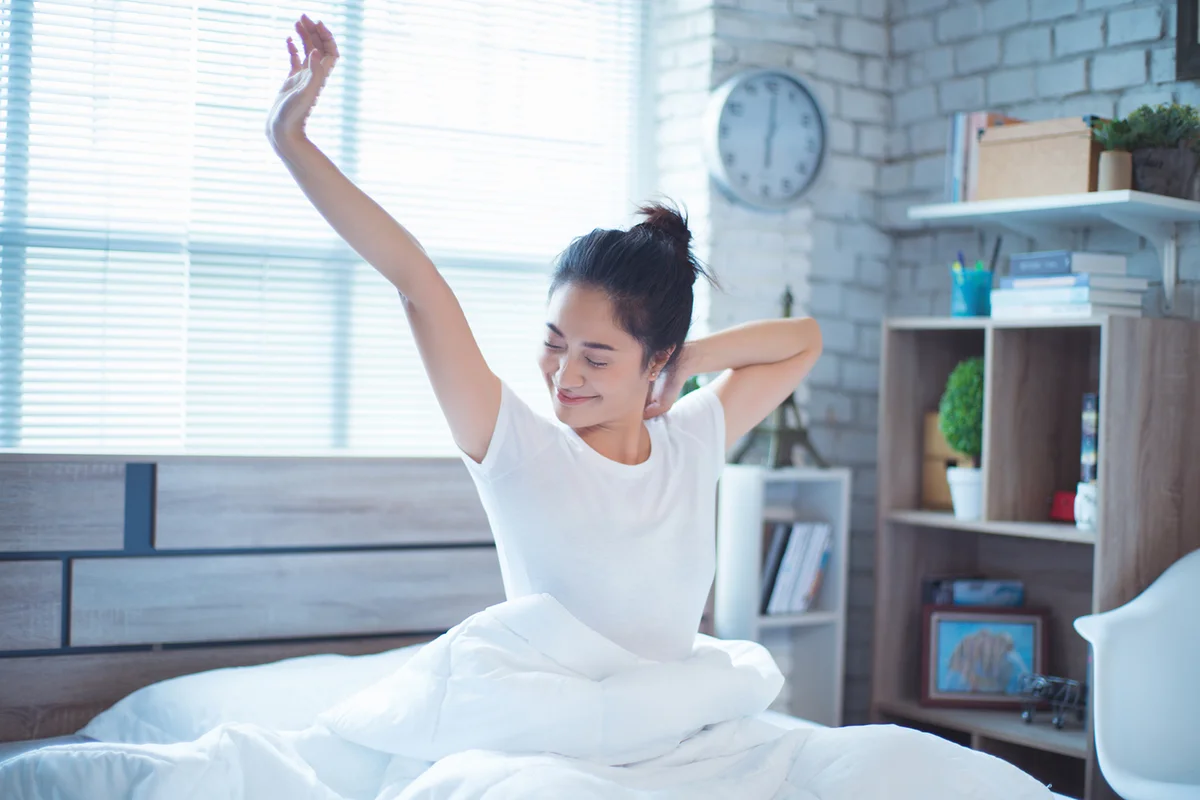 Woman in bed waking up in the morning