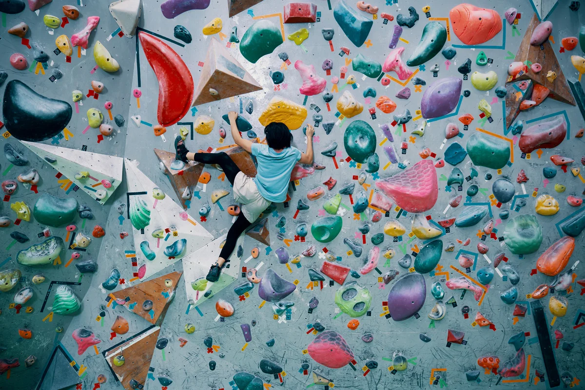 Teenage girl climbing a bouldering wall at a rock climbing