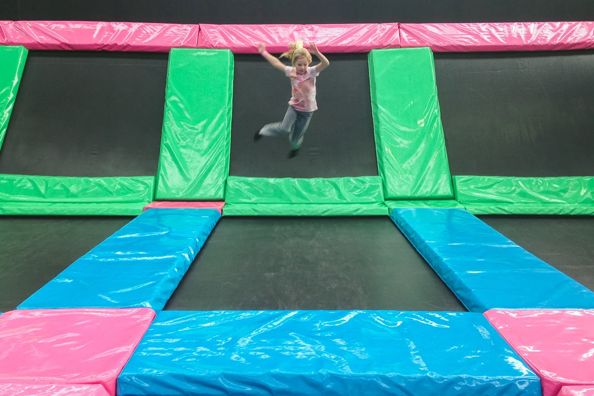 Child jumping in air at indoor trampoline centre