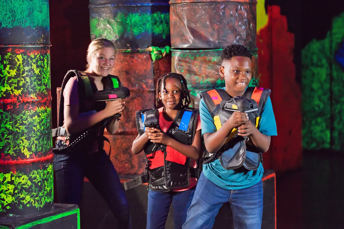 Three children playing laser tag