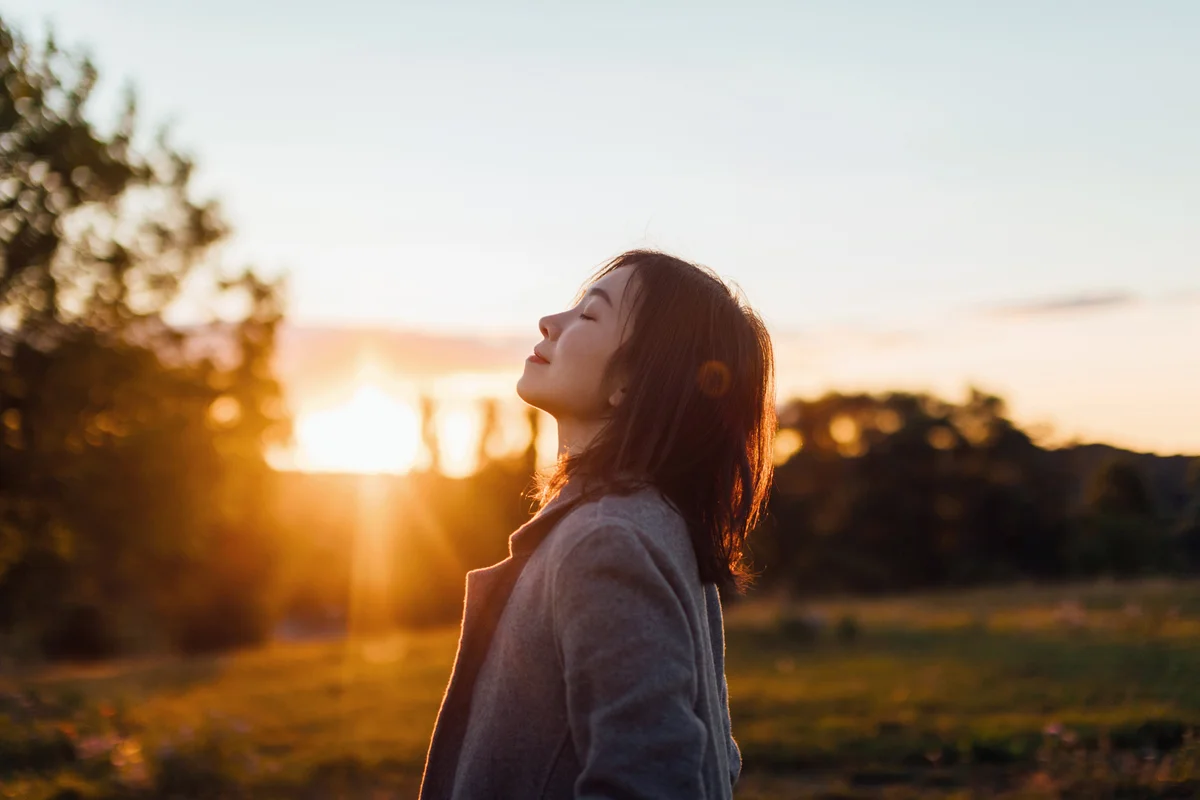 Young Woman Taking A Breath Of Fresh Air In Nature