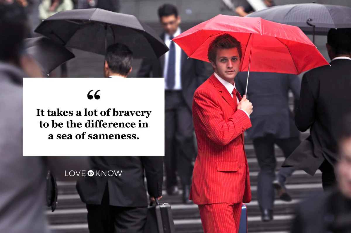 Man wearing red suit, holding umbrella in city