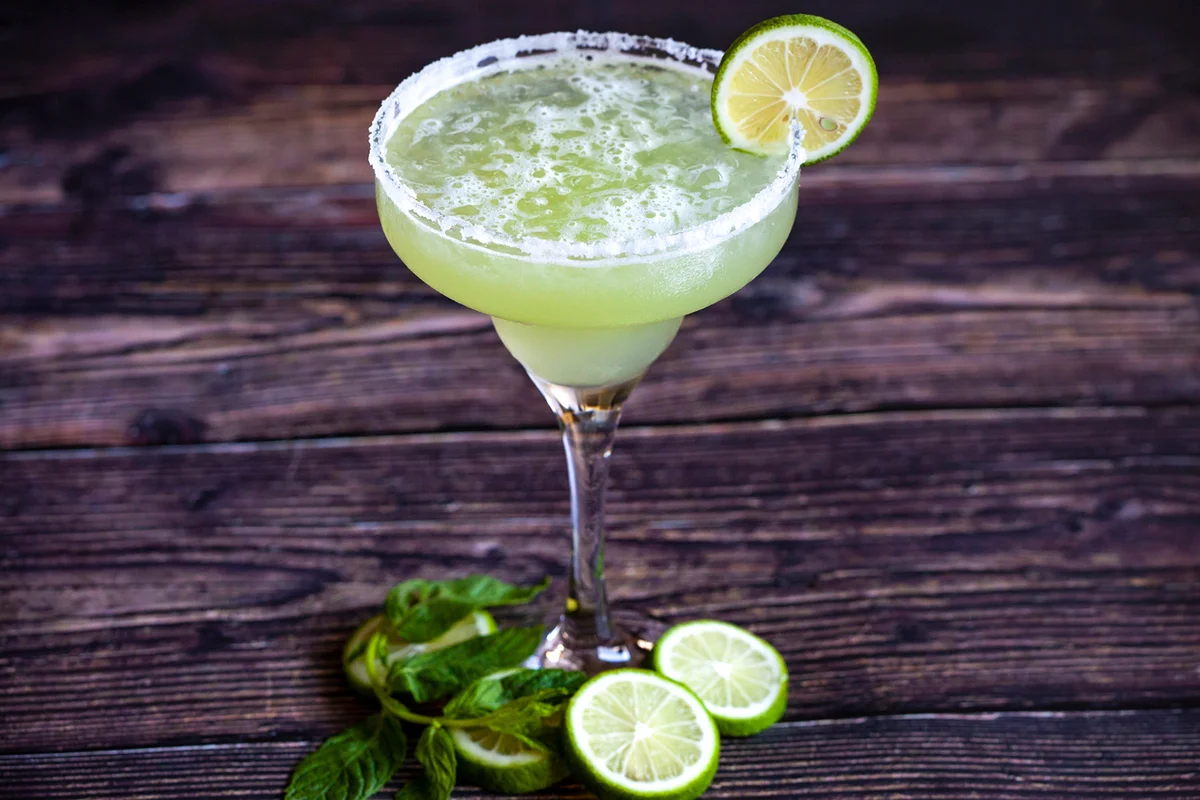 Agave margarita with lime wedges and salted glass