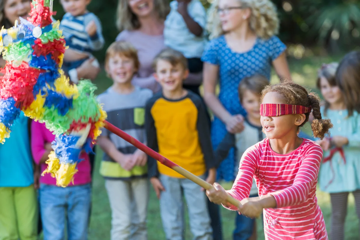 children hitting a piñata at cinco de mayo theme birthday party