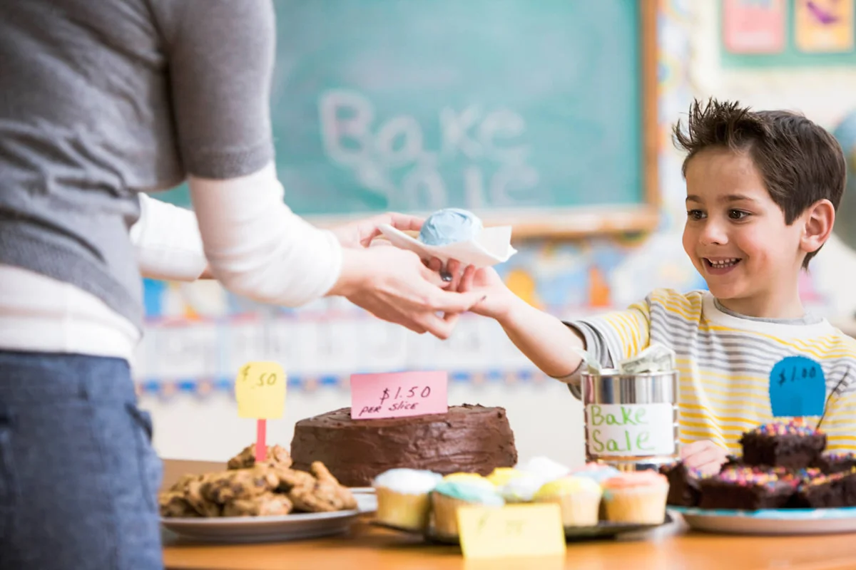 boy buying cupcake at bake sale