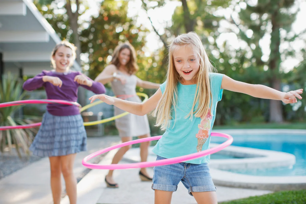 Mother and daughters hula hooping outdoors