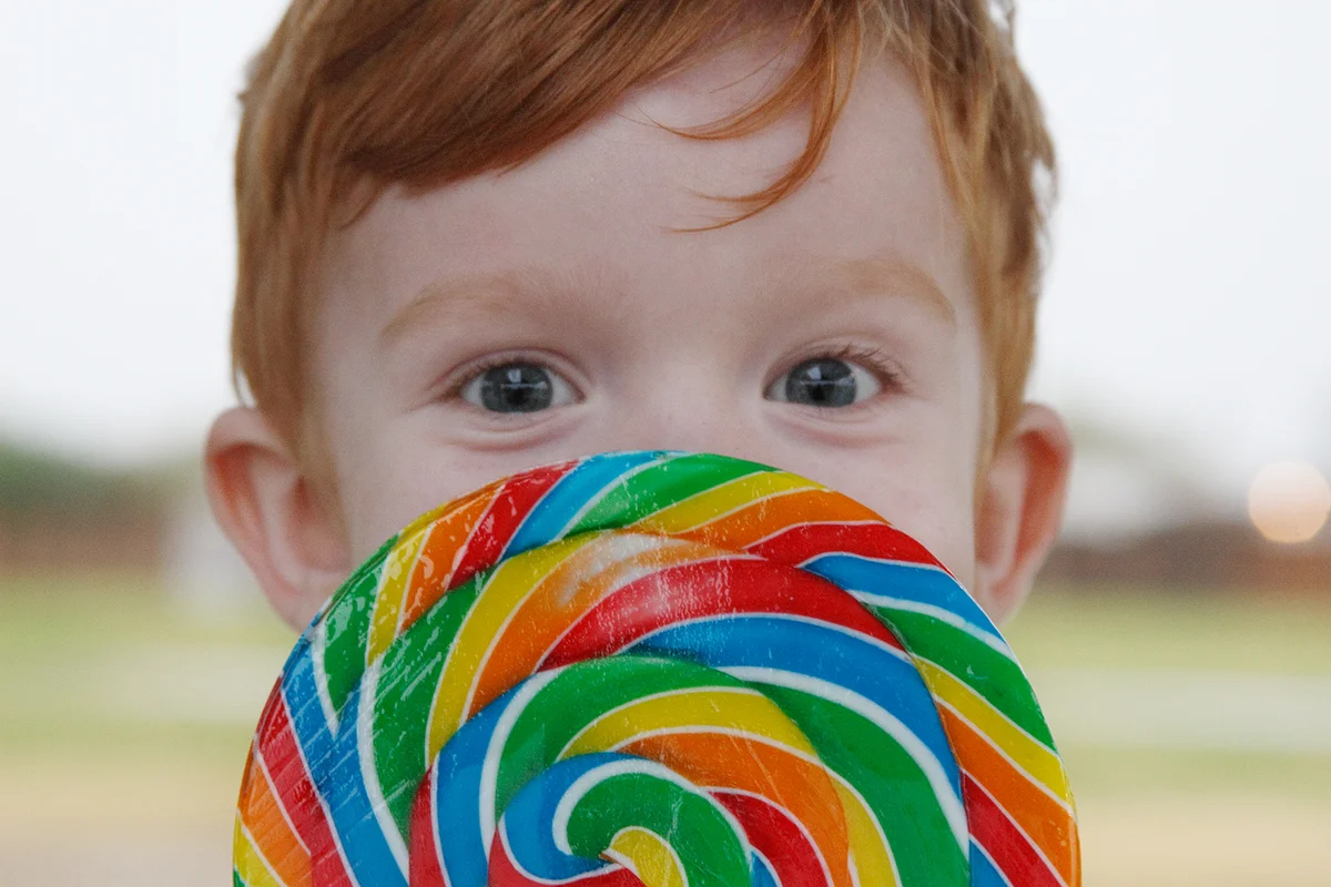 Young Boy Behind Rainbow Lollipop