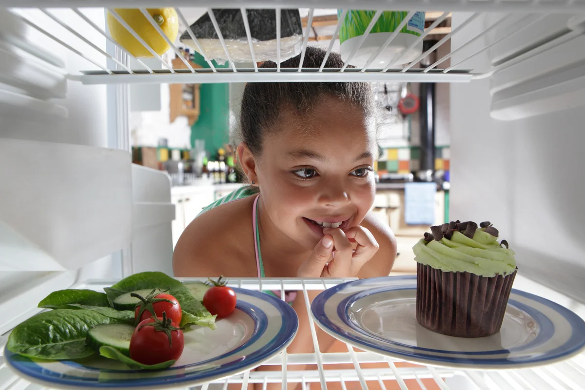 girl choosing between salad and cake