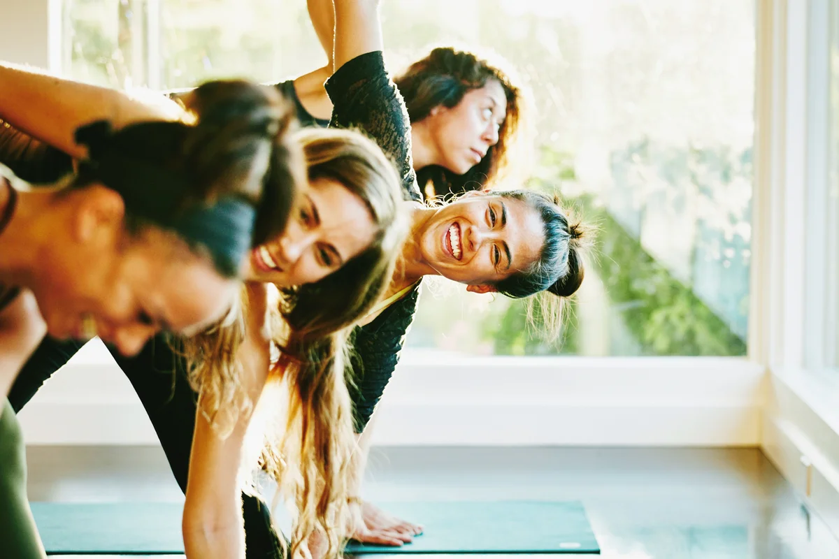 Woman laughing with friends during yoga class