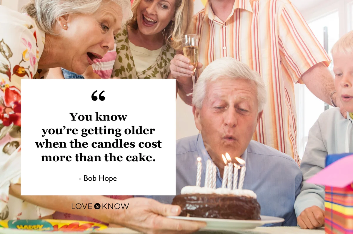 elderly man blowing out candles on his birthday cake