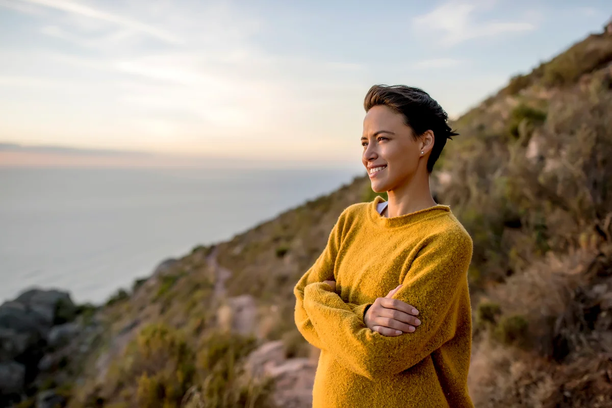 Smiling woman looking at view at sunset