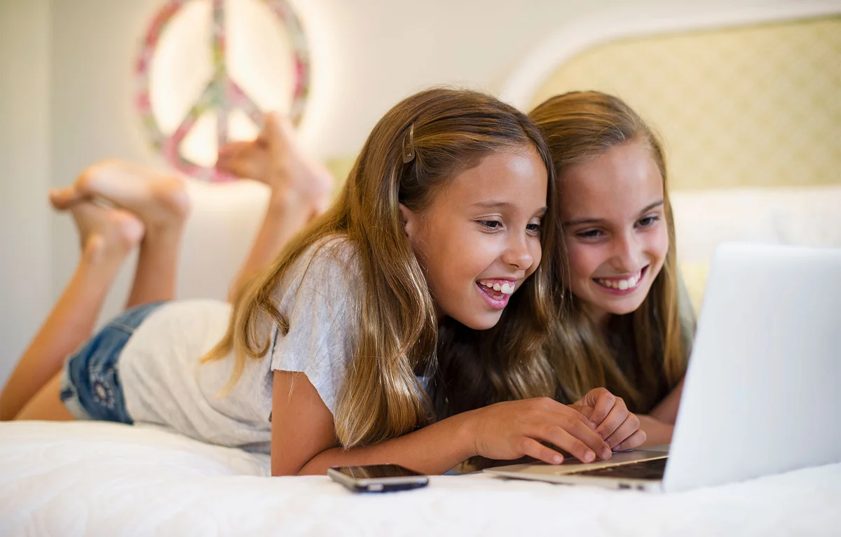 smiling girls on computer together