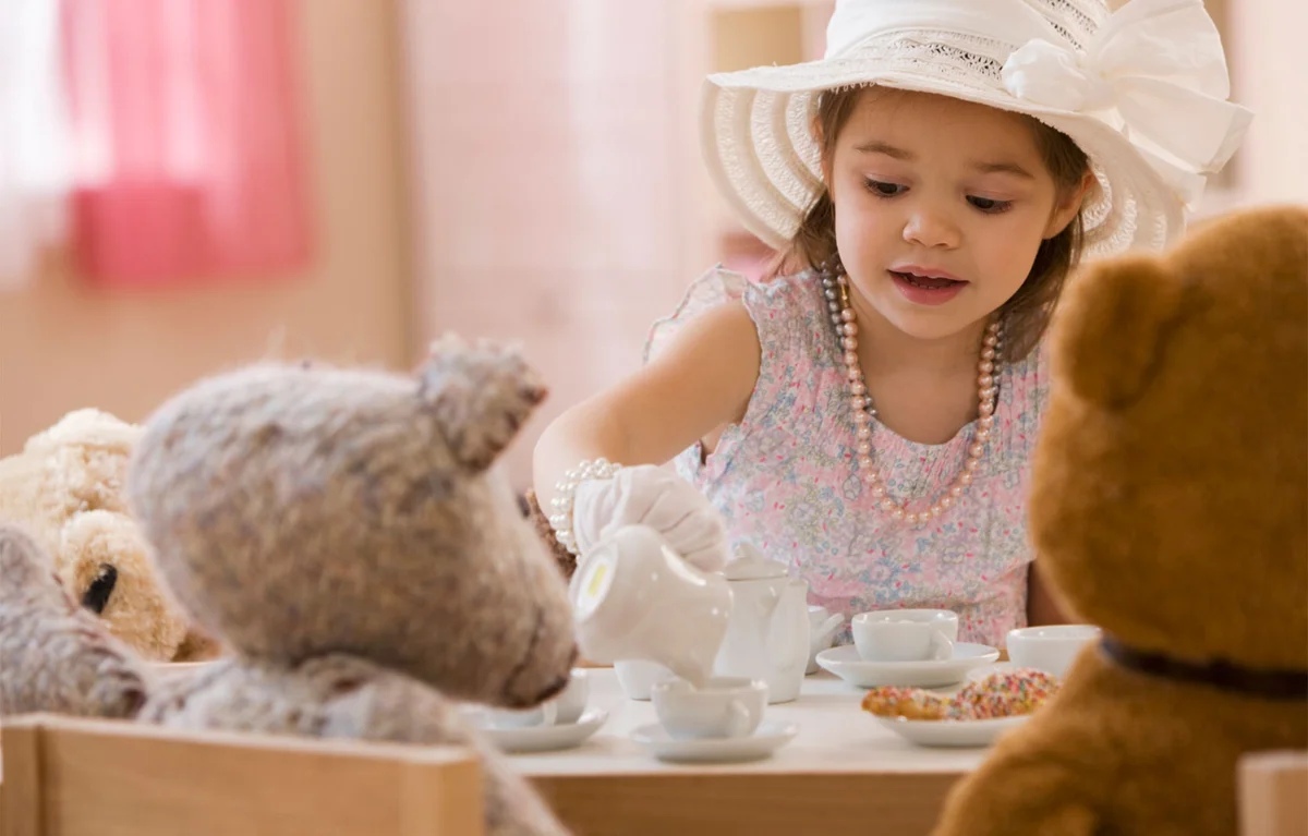 young girl having tea party with bears