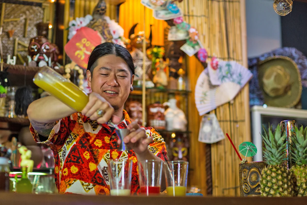 Bartender mixing cocktails in a tropical themed bar