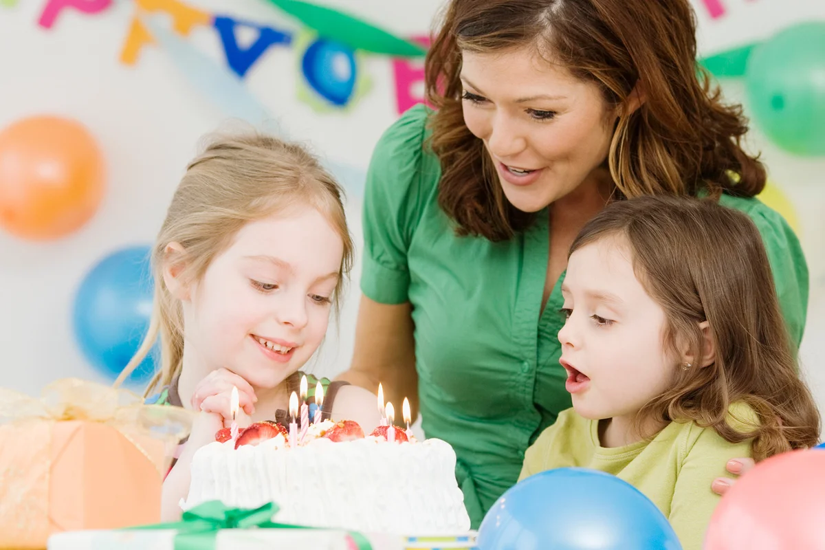 Girl celebrating birthday with mother and sister
