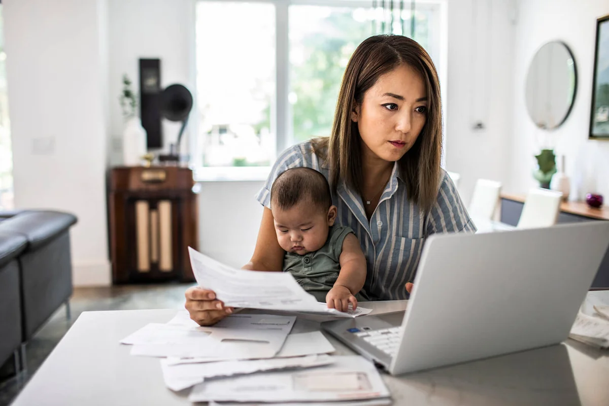 Mother working from home while holding baby