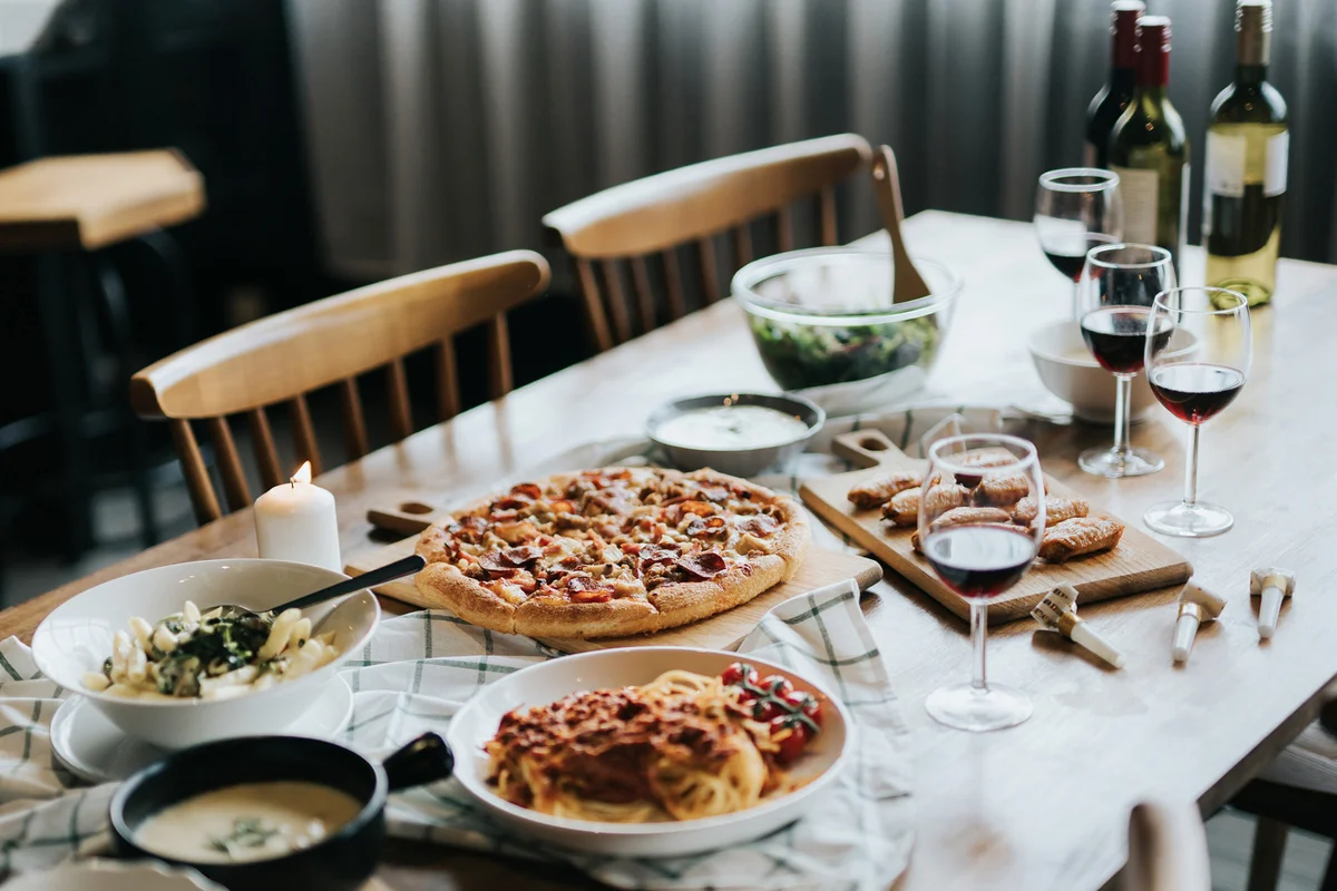 Dining table set up with pizza and wine ready for party