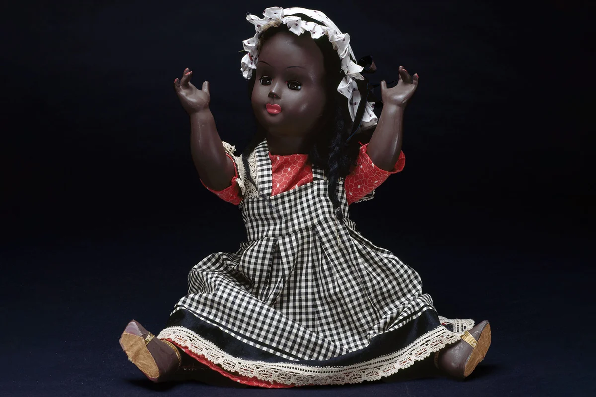 antique doll with checker print dress