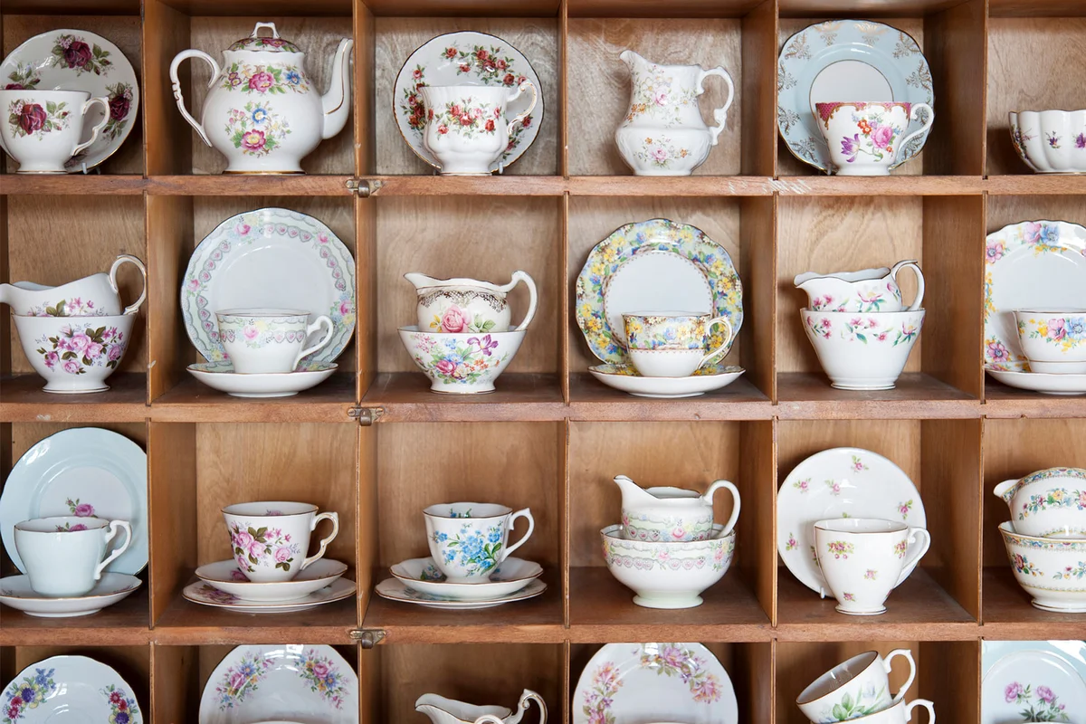 antique china plates and teacups on display shelf
