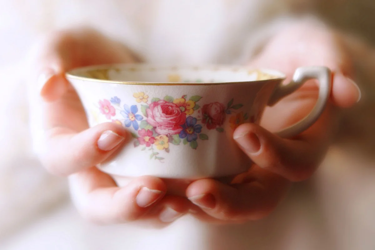 hand holding antique tea cup