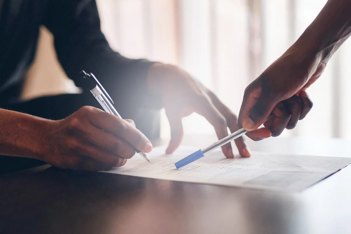 Unrecognizable man filling a document