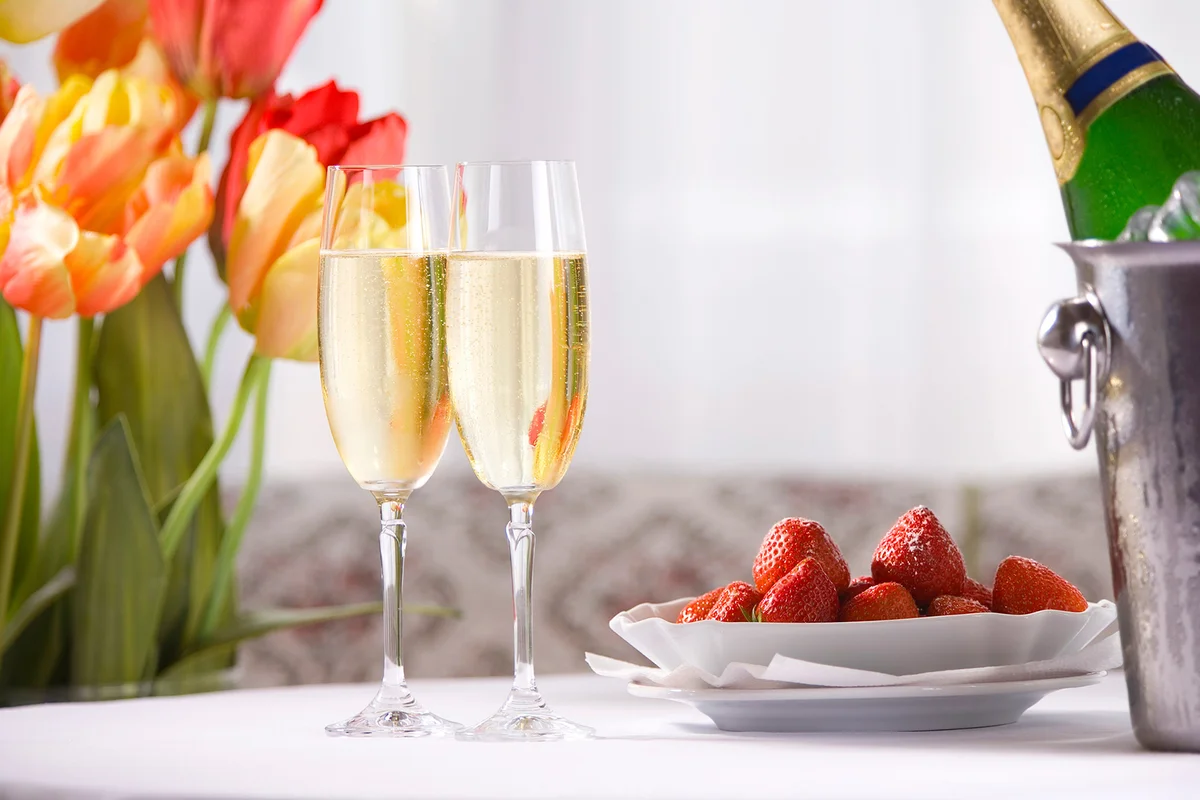 Spring still life with champagne wine , strawberries and tulips
