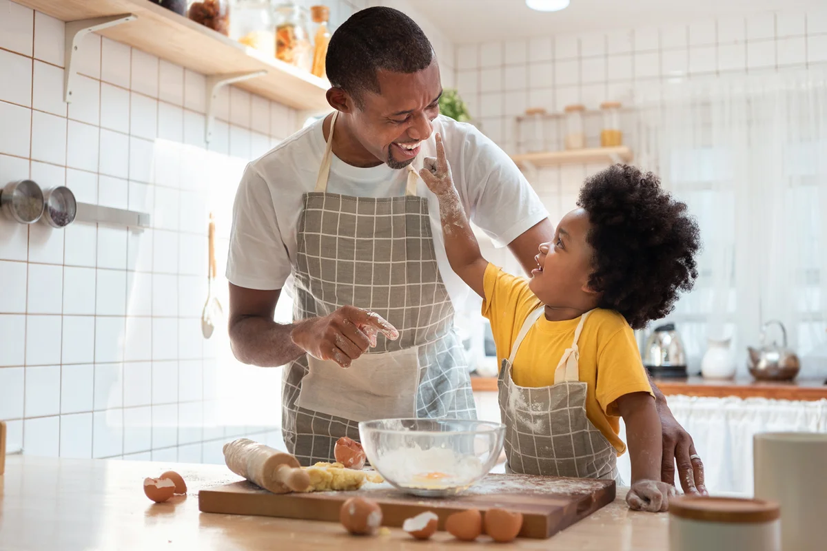 African Father and son enjoying during bake cookies at home together