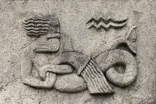  Aquarius or Water-bearer, a stone relief on ancient wall 