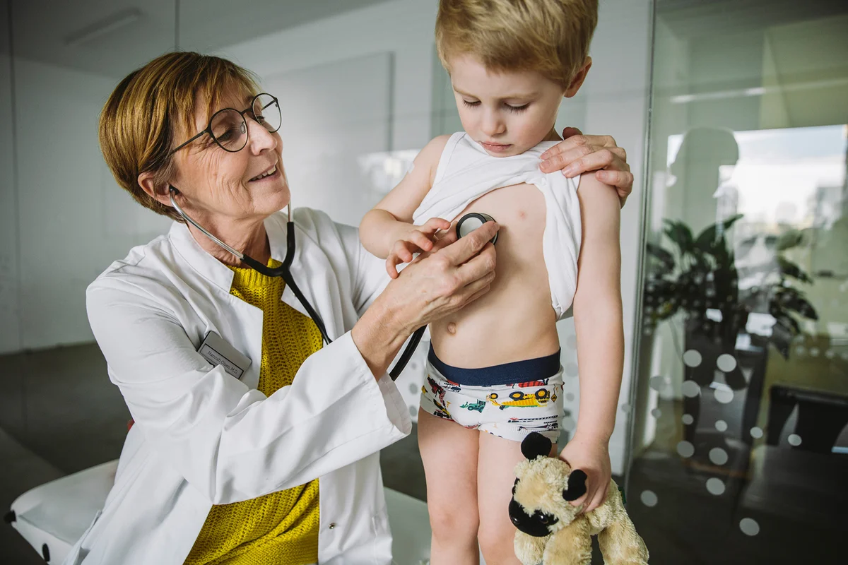 Doctor examining toddler boy with a stethoscope