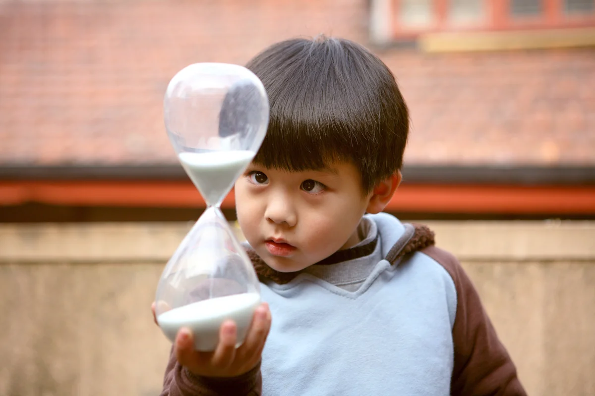 Boy looking at hourglass