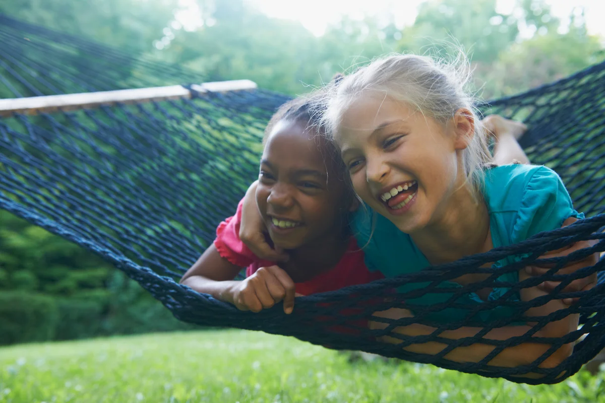 two girls laughing in hammock