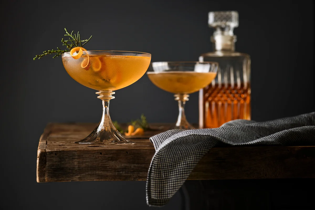 Two vermouth cocktails garnished with orange