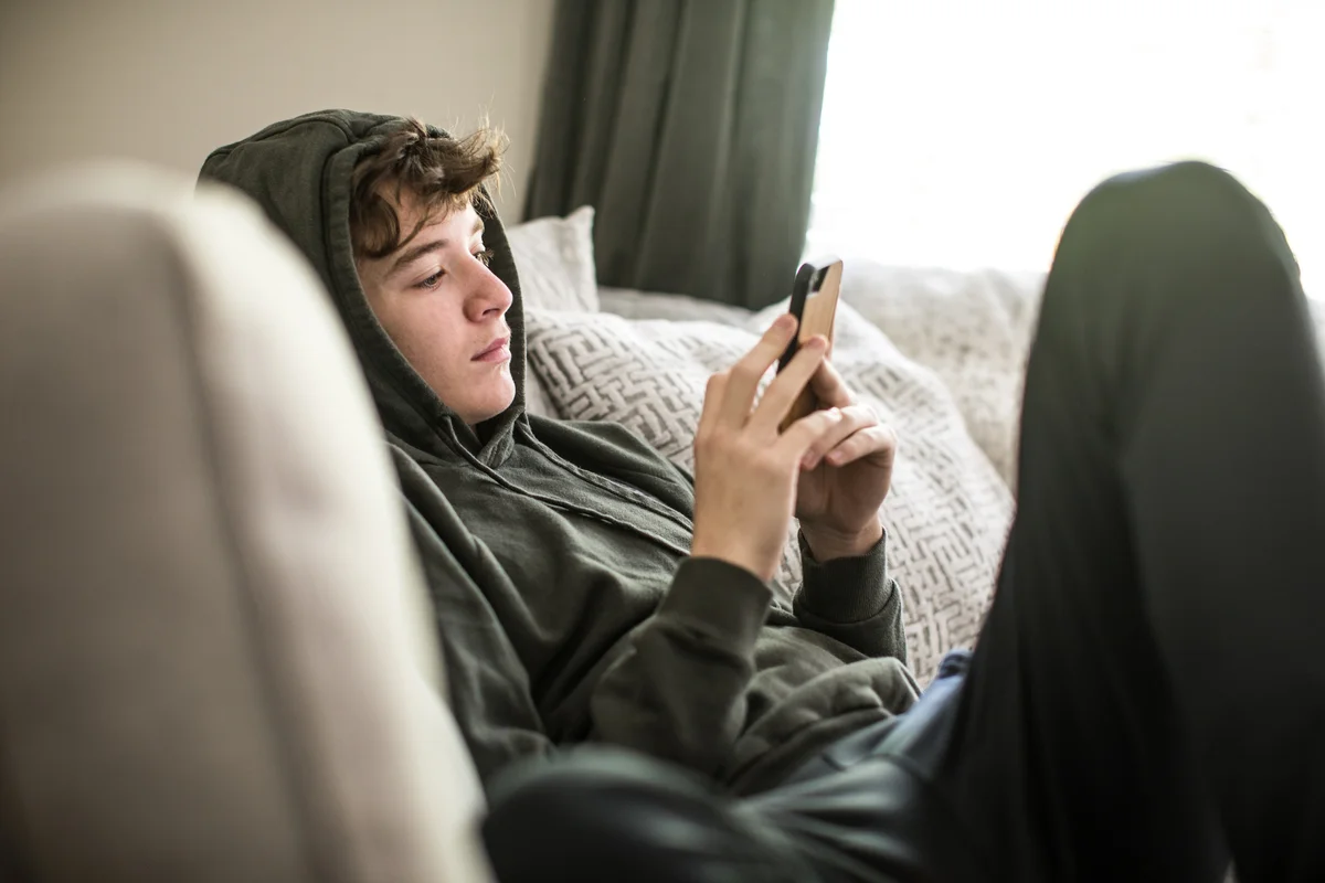 teen boy spending time alone texting
