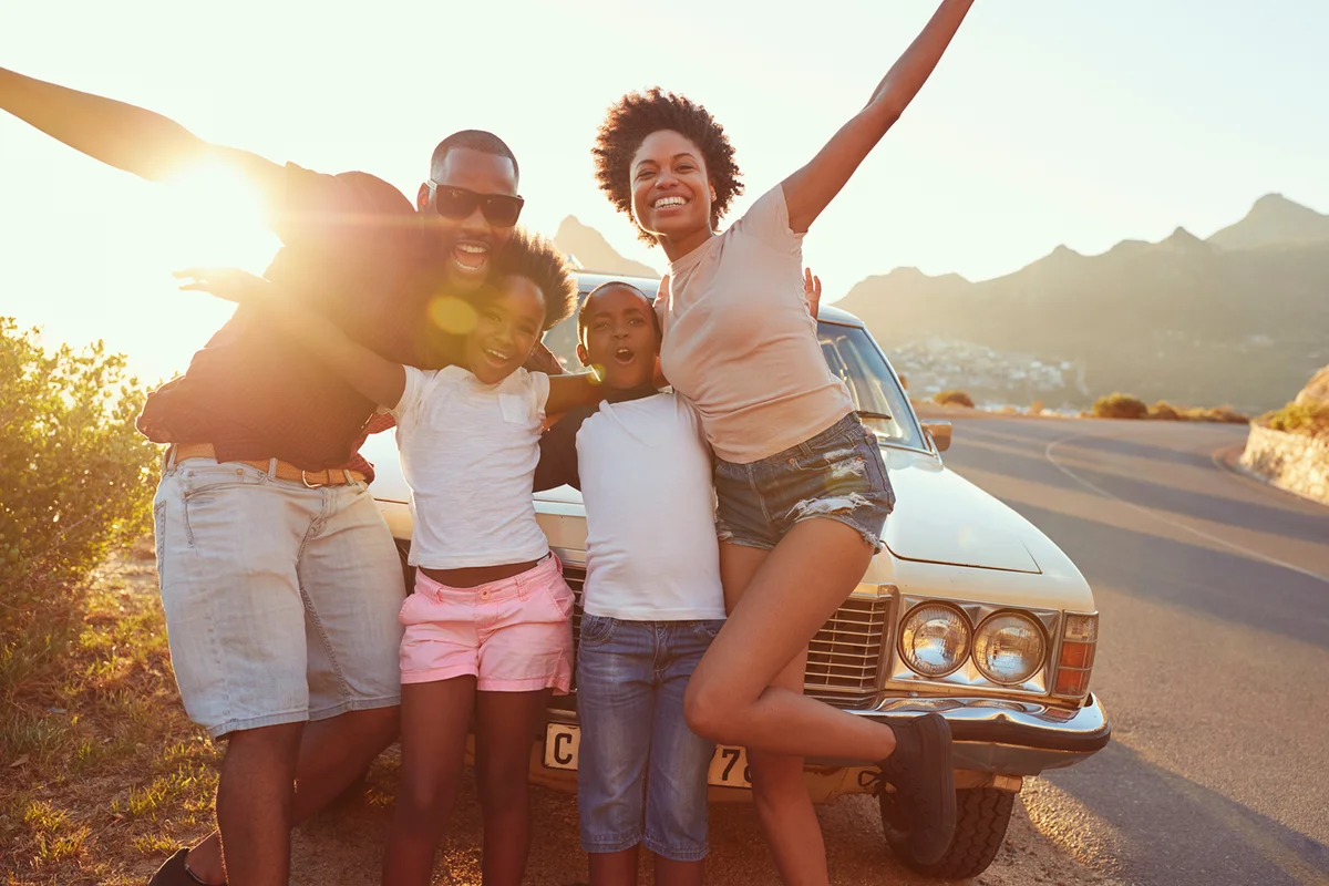 Portrait Of Family Standing Next To Classic Car