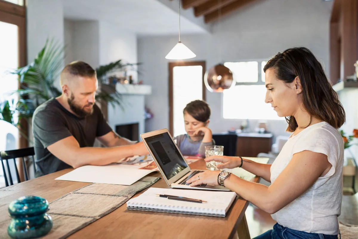 mom working at home with family in background