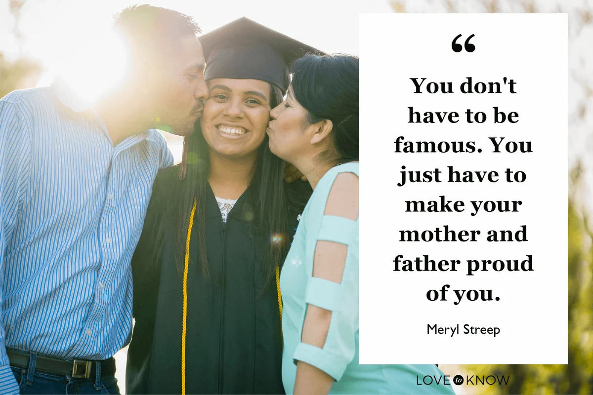 Mother and father kissing daughter at graduation