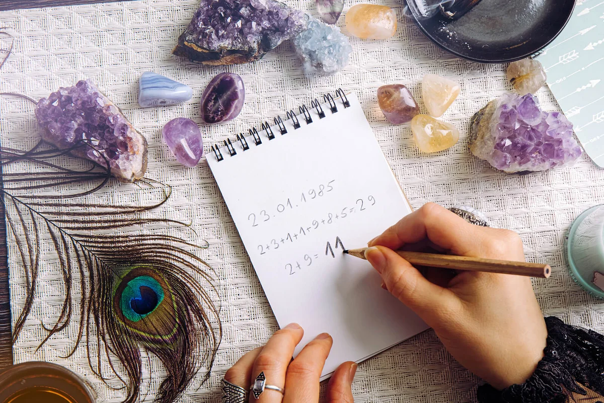Top view of woman hands do math, calculate Life path number on paper in home