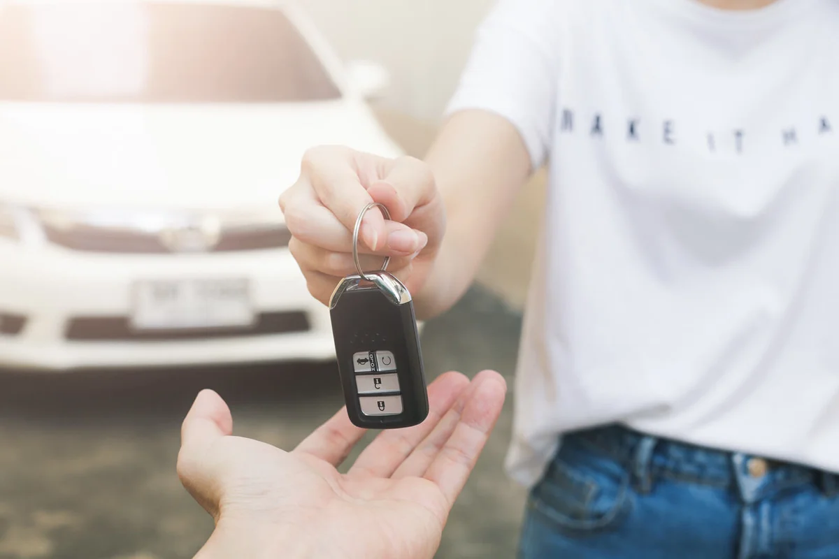 Hand of business woman gives the car key