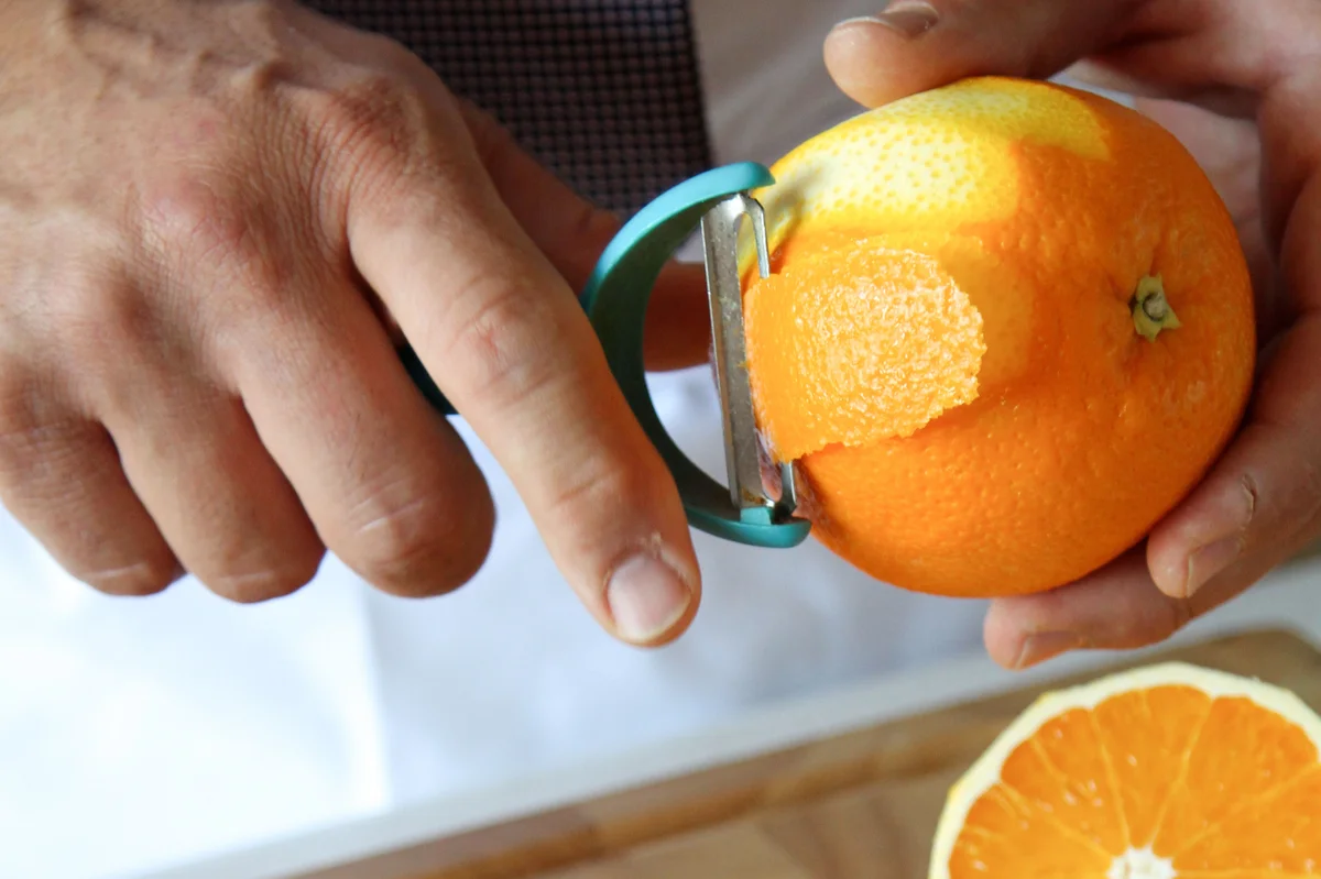 orange rind using peeler for cocktail garnish