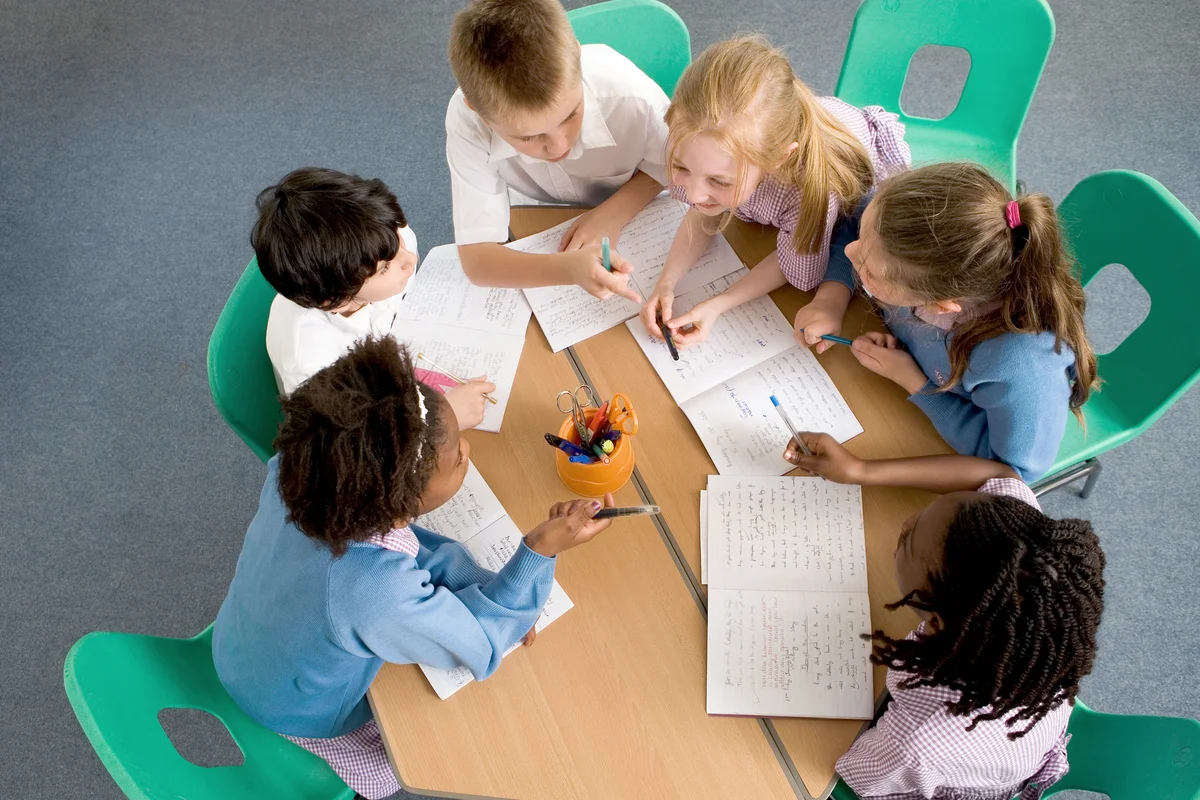 Children sitting around table, having a discussion