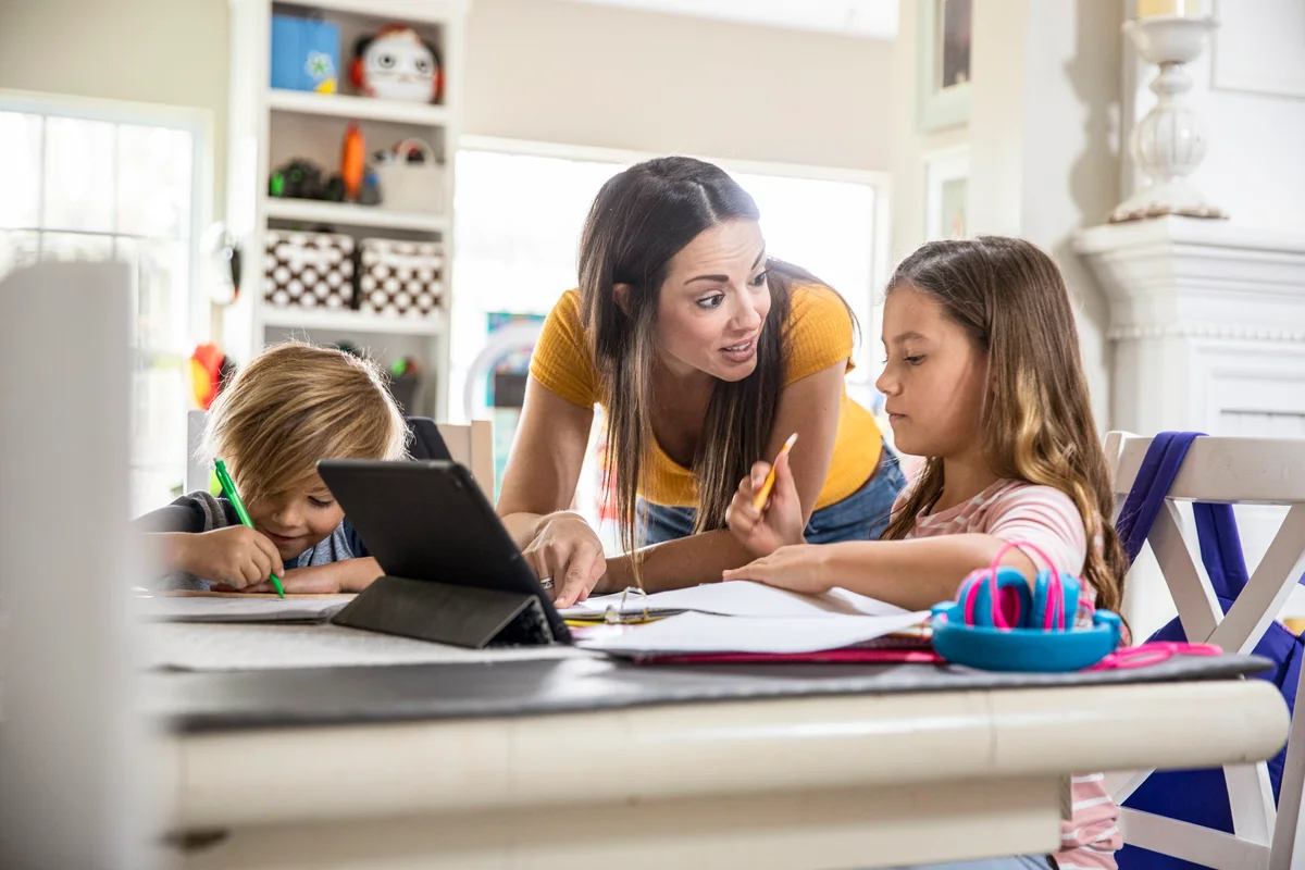 Mother helping children with their schoolwork