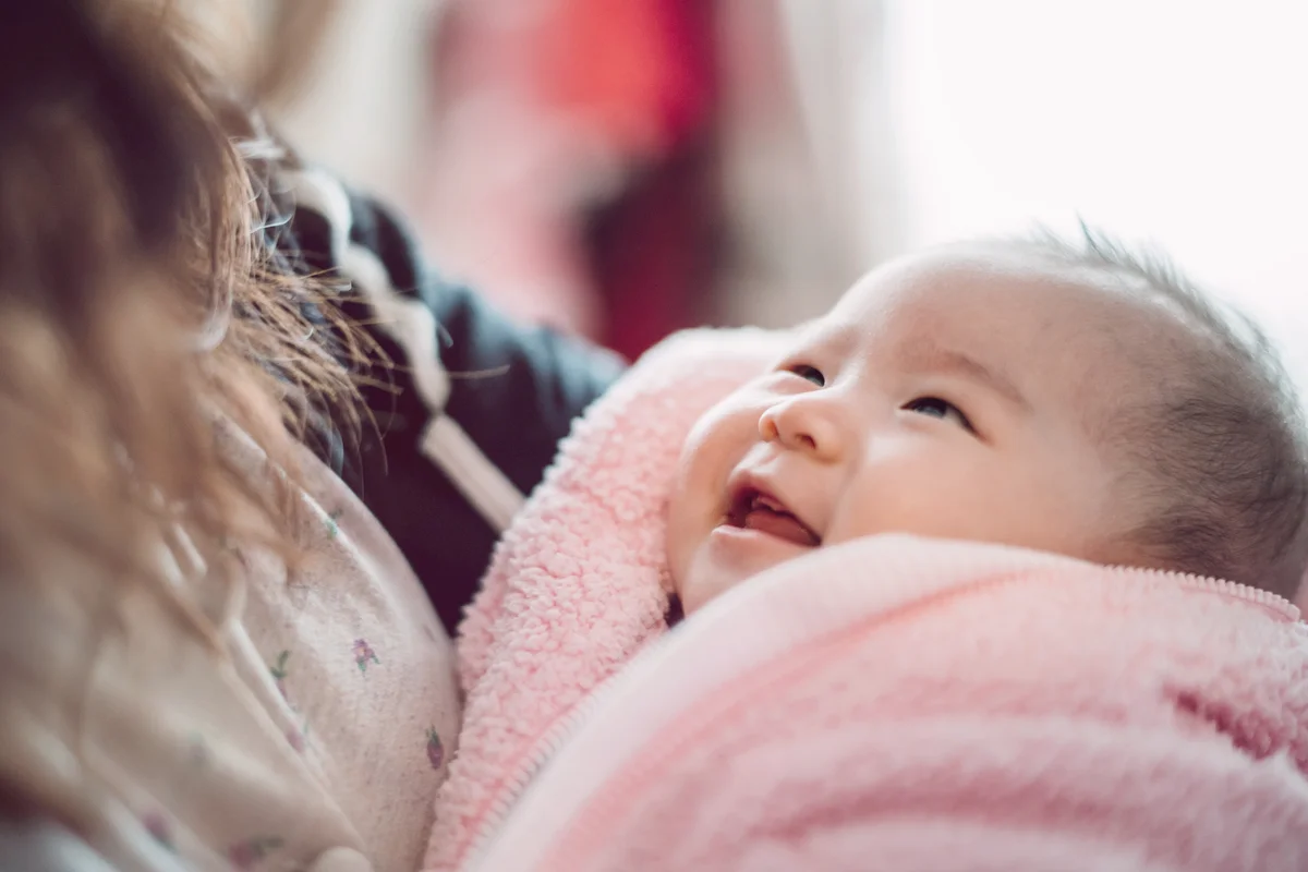 Adorable baby smiling joyfully at her mom