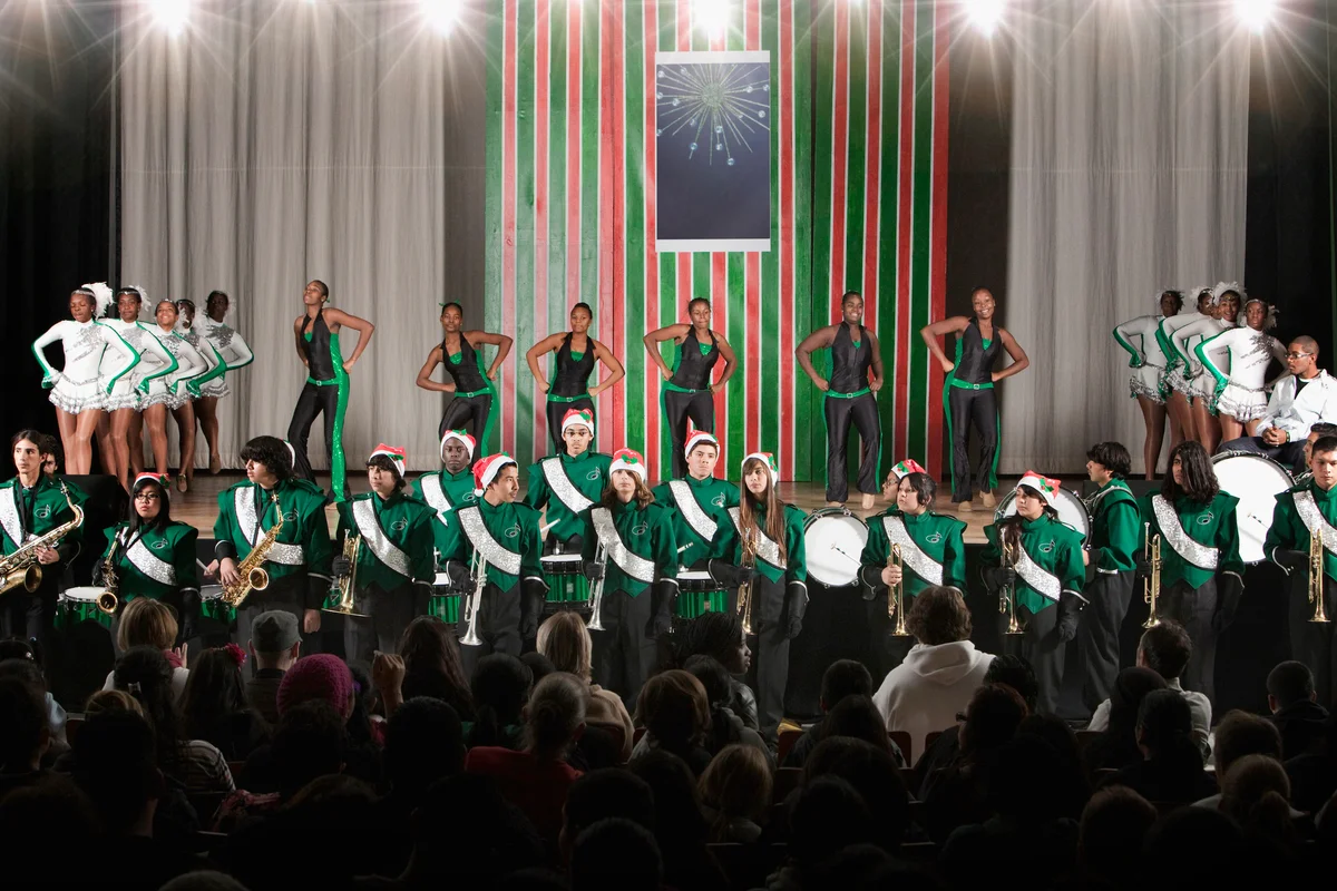 High school dance team and marching band performing on stage