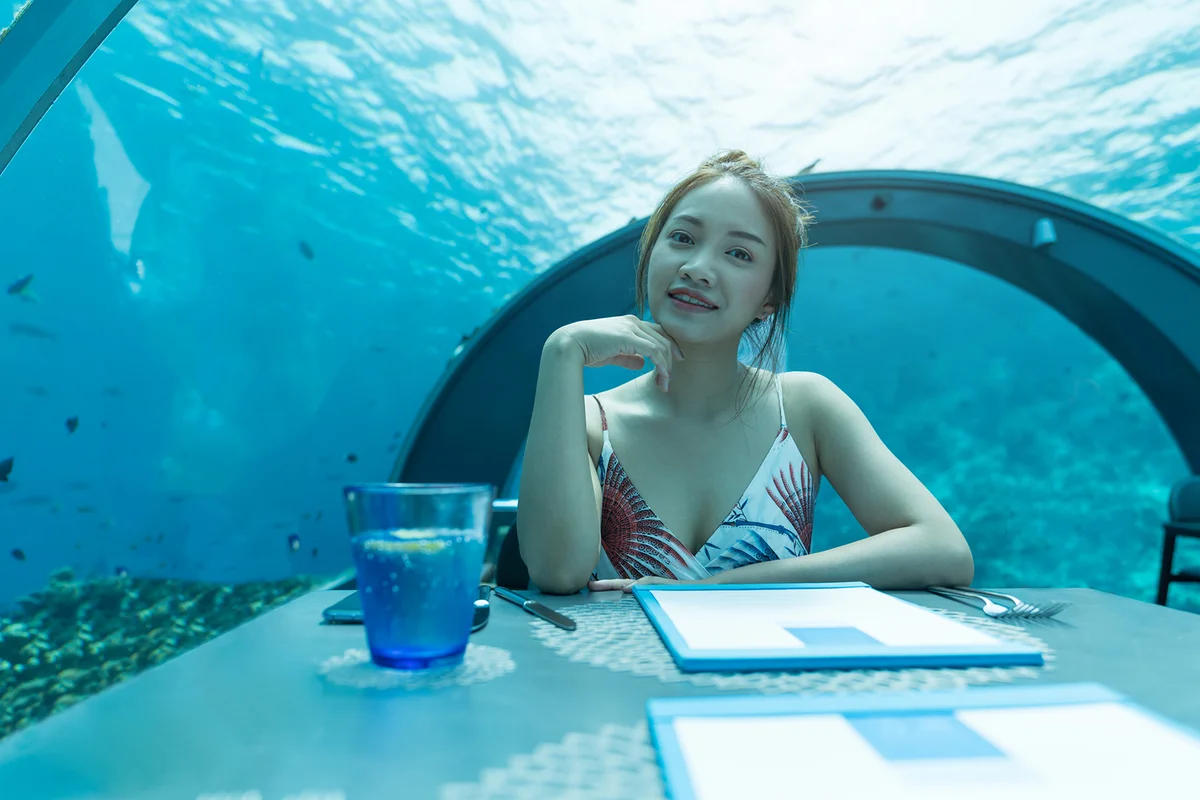 Beautiful woman dinner on undersea world