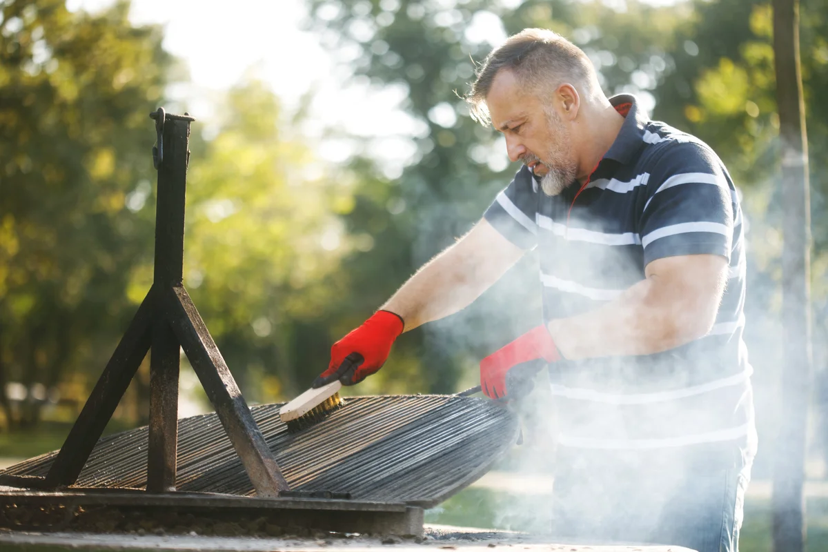 Man cleaning the barbecue grill