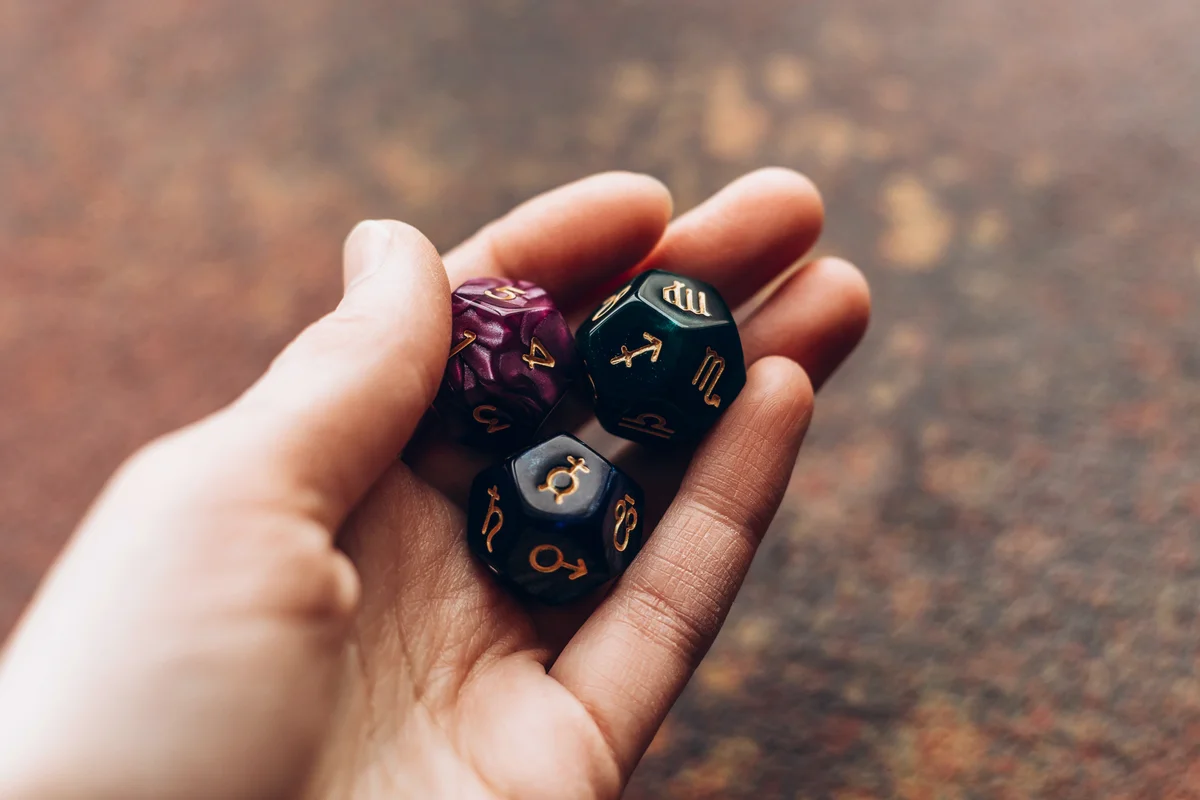 Beautiful astrological cube with different signs and numbers in woman hand