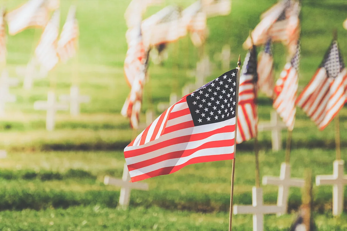 Single focus on American flag on Memorial Day with flags and crosses
