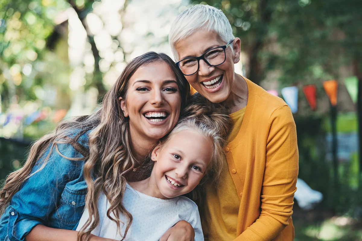 Three generations - happy grandmother, mother and daughter in the back yard