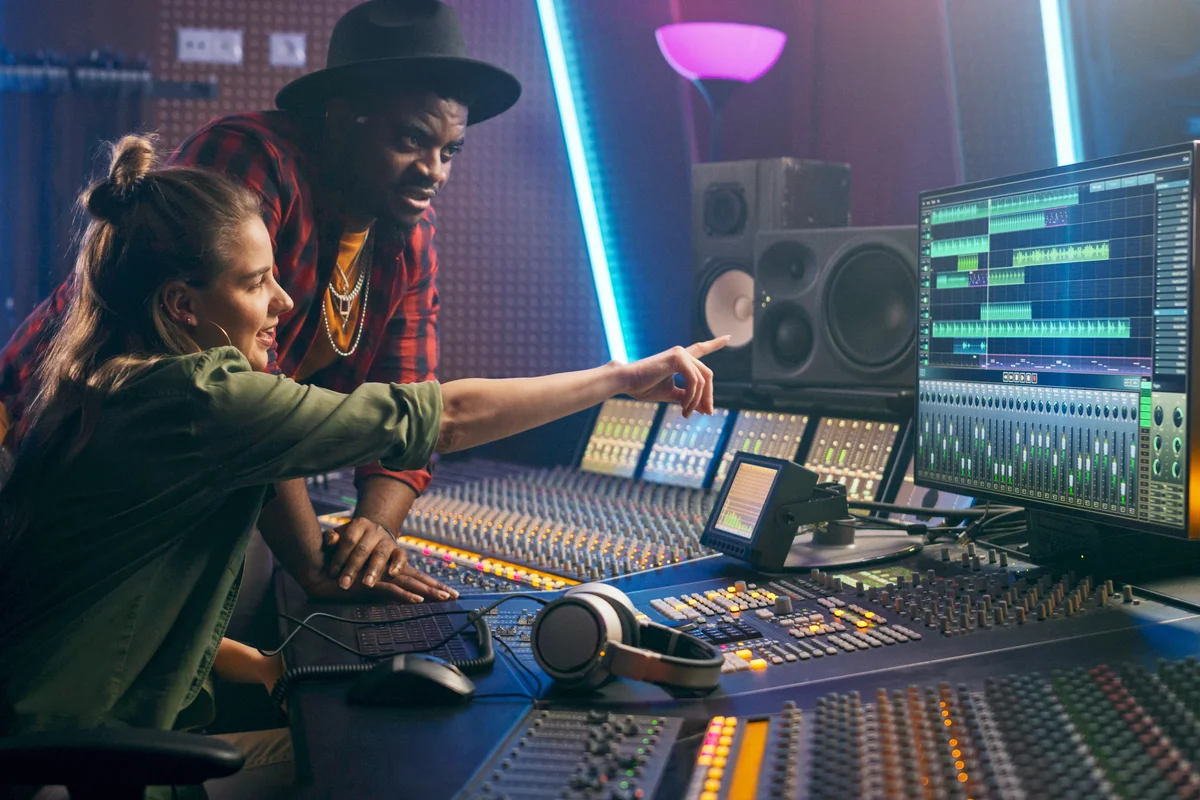 Producer and Professional Audio Engineer Working together in Music Recording Studio